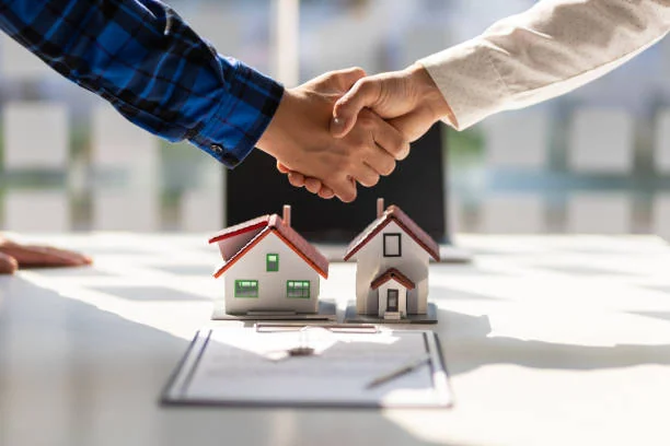 Handshake over two model houses