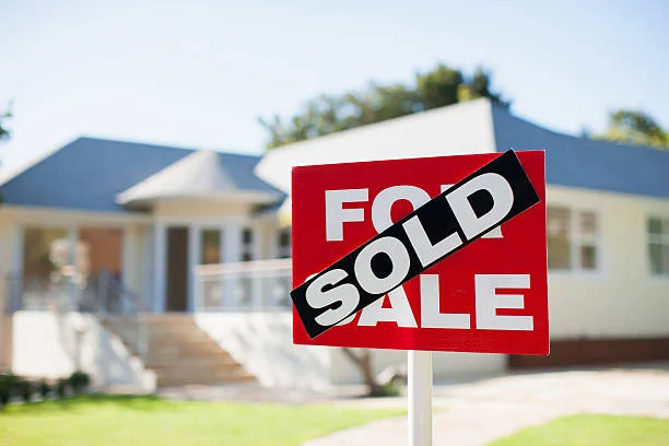 For Sale sign with a Sold sticker