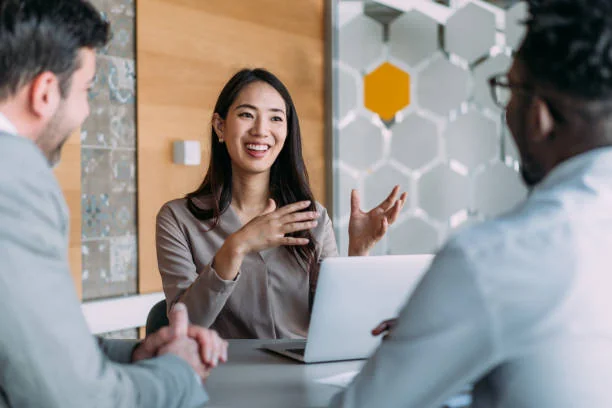 Smiling agent with a laptop talking with two clients