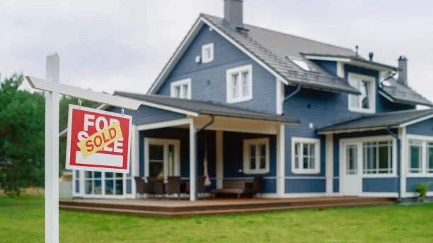 Blue house with a sold sign in the front yard